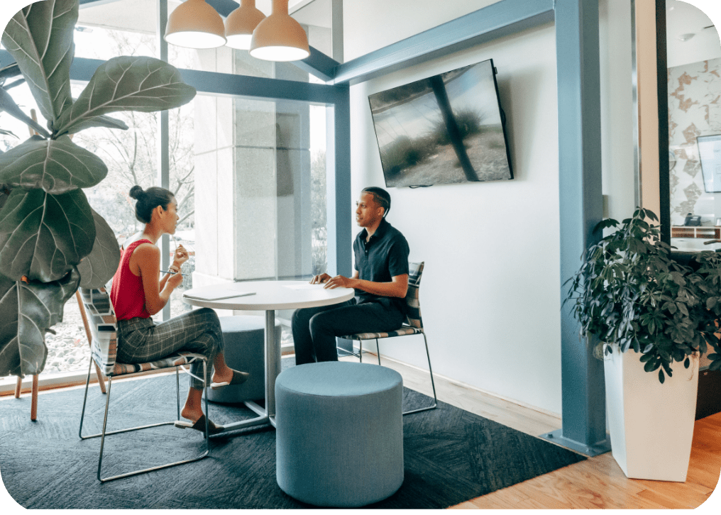 Two individuals engaged in an interview process, sitting at a table in an office.